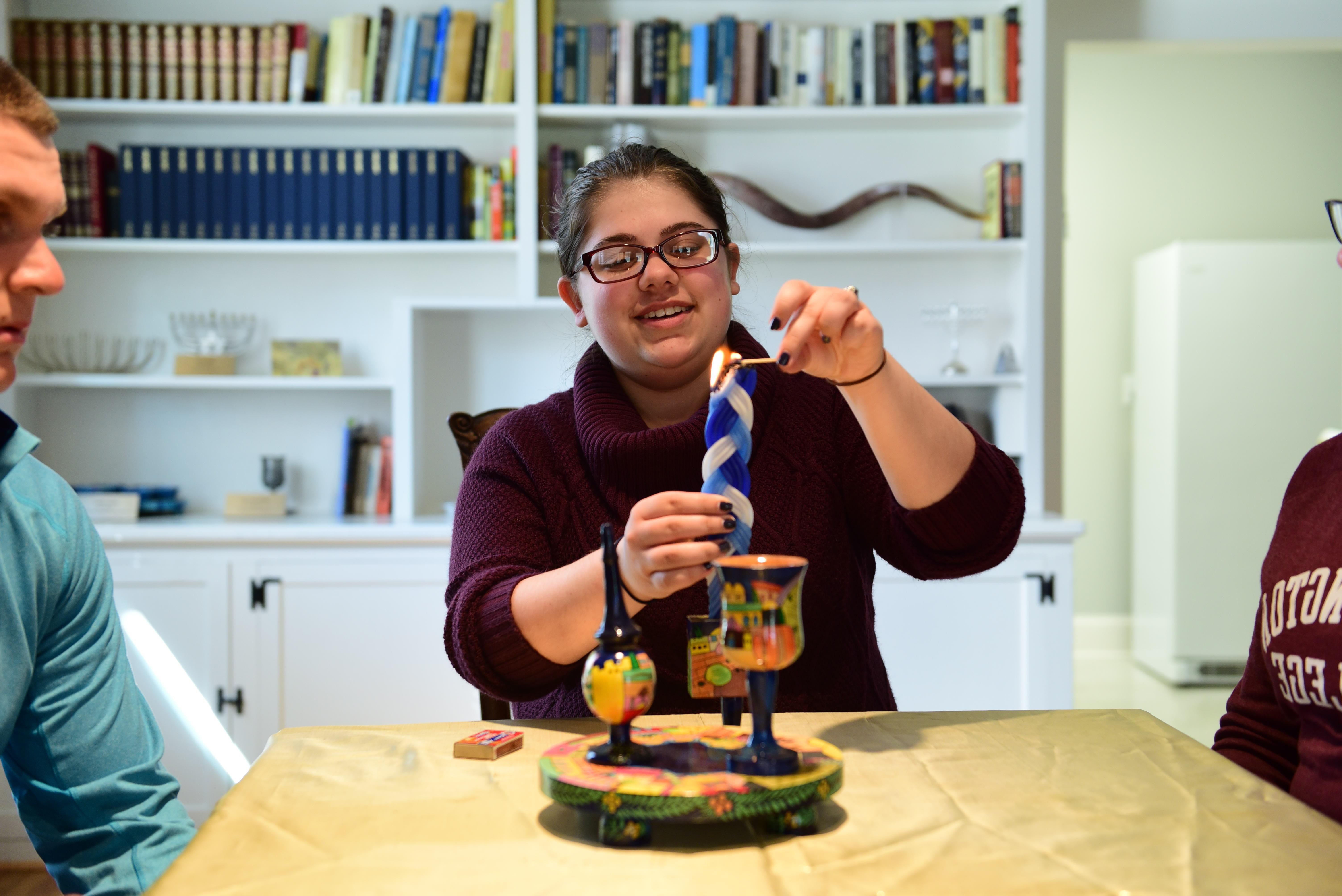 WC Hillel Student lights a candle 