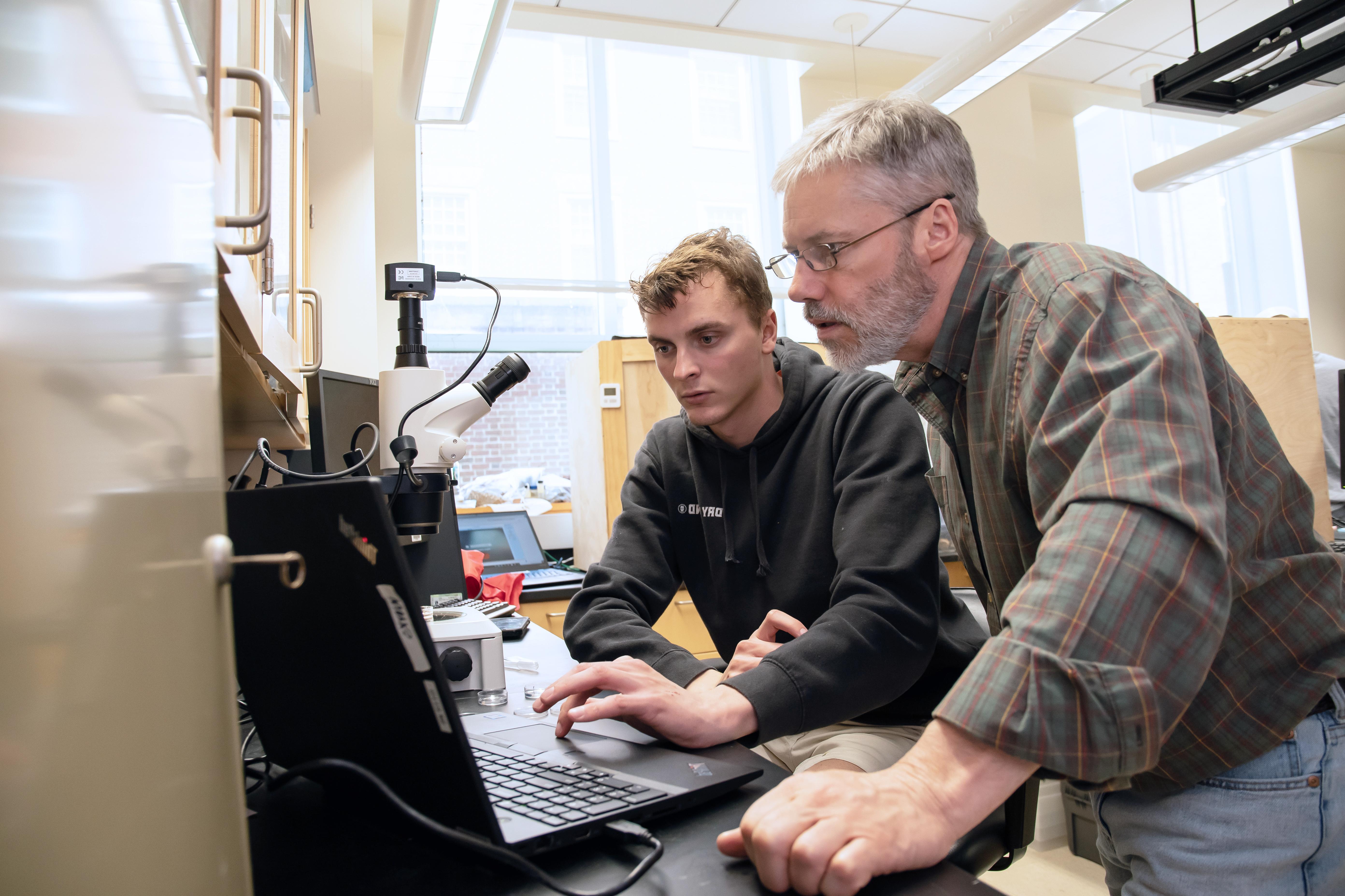 Professor and student looking at computer